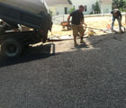 landscaper spreading and grading asphalt